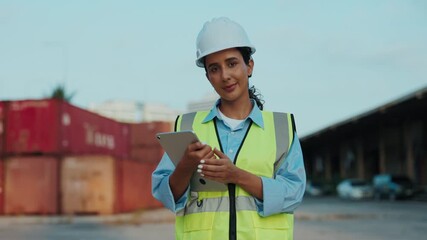 Portrait Of A Young Warehouse Supervisor Standing And Holding A Tablet, Dressed In A White Helmet And A Yellow Vest. The Worker, Dressed In Safety Uniform, Holds A Digital Device Smiles At The Camera - Powered by Adobe