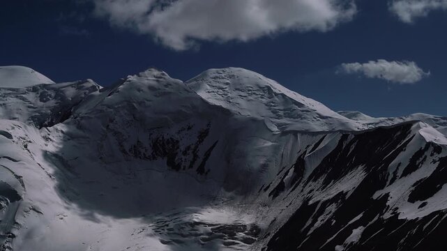 Incredible night running clouds 4K timelapse over Pamir mountains shooted from 5150m Yuhin peak with Krasin peak and Pik Dzerzhinskogo 6717m on Background. Beauty in Nature and extreme sport concept