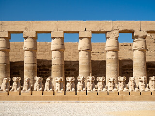 The entrance of Karnak Temple, featuring rows of ram-headed sphinx statues lining the Avenue of...