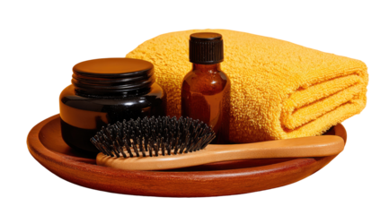 Hair care supplies arranged on a wooden plate.  A dark jar, small amber bottles, a yellow towel, and a black bristle hairbrush rest on a round wooden plate