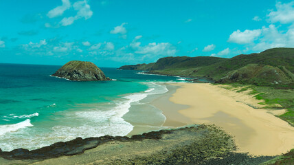 Obraz premium Vista aérea da Praia do Leão em Noronha, com mar turquesa, areia clara e vegetação preservada em ambiente paradisíaco