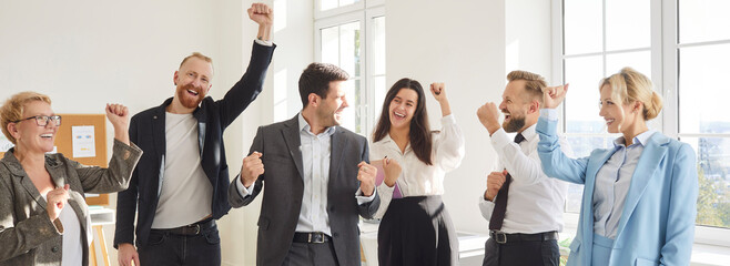 Team of happy business people celebrating success while working together during a meeting in the...