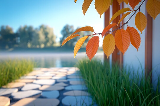 Autumn leaves near a building with a stone path leading to a misty lake under a clear blue sky day