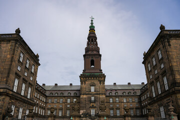 Obraz premium The ornate towers of a historic landmark building, possibly Christiansborg Palace, against a sky in Copenhagen, Denmark.