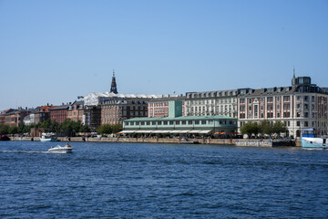 Fototapeta premium A view from a boat of the Copenhagen cityscape across the wide harbor waters in Denmark.