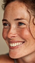 Obraz premium Smiling woman with freckles, showcasing vibrant, healthy skin, radiating confidence and warmth; ideal for beauty, portrait, and lifestyle themes in photography collections.
