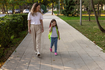 Mother and daughter enjoying a walk in a park on a sunny day