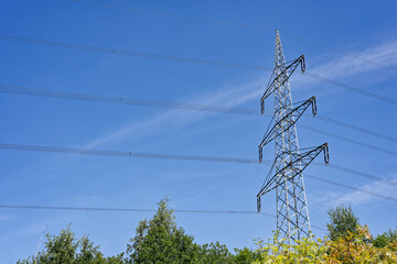 Tall electric power pole with three rows of cables on blue background