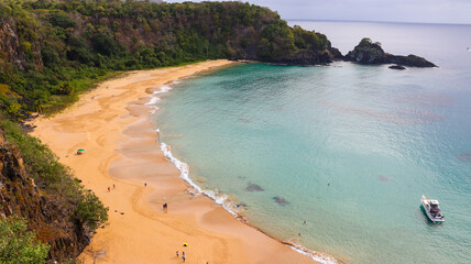 Aerial drone shot of Praia do Sancho in Fernando de Noronha, with emerald waters, lush cliffs, and pristine golden sand in a world-renowned paradise