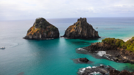 O Morro Dois Irmãos e a Baía dos Porcos formam um dos cartões-postais mais icônicos de Fernando de Noronha, com águas esverdeadas, rochas vulcânicas e cenário único do litoral brasileiro © RNL Fotografia