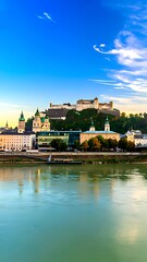Obraz premium Panoramic view of a city skyline reflected in a calm river at dawn.