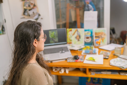 Graphic designer working from home studio editing photos on laptop