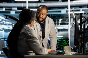 Data center engineering team running diagnostic scripts on computer, examining hardware. Server...
