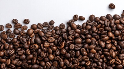 Obraz premium Coffee Beans Scattered on White Surface in Close Up