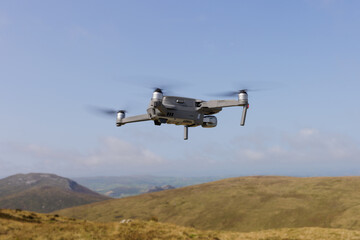 A close-up view of a drone flying over the countryside