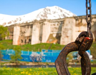 Fototapeta premium Rusty hook on chain against ancient wall