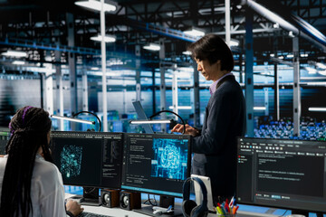 Data center developer monitoring AI systems, adjusting machine learning parameters. Server hub IT...