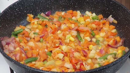 A woman fries vegetables in a frying pan at home. healthy food, diet, low calories, diet....