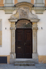 Artistic carved wooden door with ornate stone arch and detailed bas-relief, showcasing elegant craftsmanship of historical architecture. Art, culture, design inspiration and architectural heritage