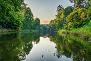 Rakotz Bridge (Rakotzbrucke, Devil's Bridge) in Kromlau, Saxony, Germany. Colorful summer, reflection of the bridge in the water create a full circle