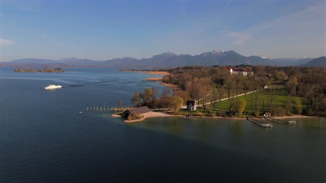 Drone view of Holy Cross Chapel on Herreninsel, Bavaria. Historic baroque chapel blends with alpine scenery, clear skies, tranquil lake and springtime nature. Luftaufnahme Seekapelle zum Hl. Kreuz. 