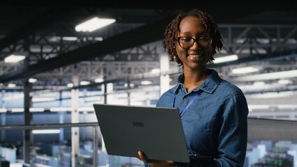 Portrait of joyful computer scientist in data center monitoring neural network LLM visualization. Upbeat woman in server farm overseeing rigs powering machine learning processes