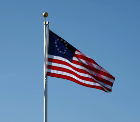 Historic American Union Flag waving under blue sky
