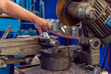 The worker using metal cutting saws for cutting steel pipe. Electric tool in the production shop.