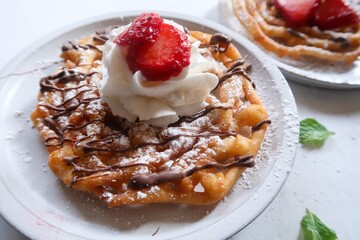 Homemade funnel cake topped with powdered sugar - summer carnival food