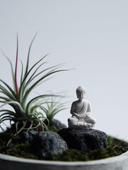 White buddha statue meditating peacefully in a zen garden