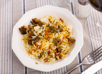 Homemade food is cooked and served in white ceramic plate. Dish consists of boiled rice and stewed...