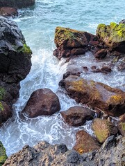 Ocean Waves Crashing on Rocky Shore with Mossy Stones
