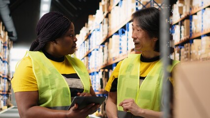 Diverse employees overseeing order details shipments for distribution, checking digital stock...