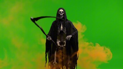 Grim reaper with scythe stands against green screen with orange smoke effect in the foreground. Halloween theme
