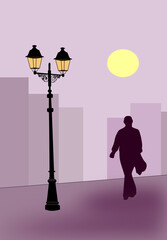 A man walking alone in the city at night and a lamppost in the foreground.
