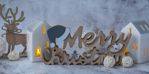 Merry Christmas wooden message with Christmas winter holiday decoration clay houses with light....