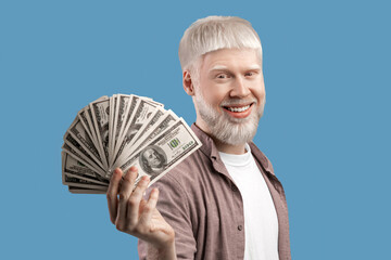 Big luck. Happy albino guy posing with lots of money, holding dollar fan over studio background....