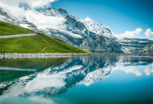 Solitary Hiker at Alpine Lake in Kleine Scheidegg with Snow-Capped Reflections in Fallbodensee