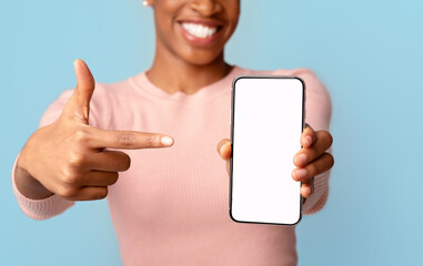 Smiling Black Lady Pointing On Smartphone With Blank White Screen In Her Hand, Unrecognizable...