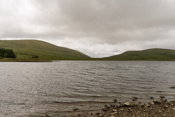 A lake with a cloudy sky in the background