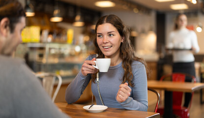 Couple, man and girl, meet in cafe for a cup of coffee. Conversation of lovers