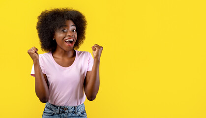 Positive african american lady gesturing YES, feeling excited and triumphant on yellow studio background. Excited black woman celebrating success or achievement