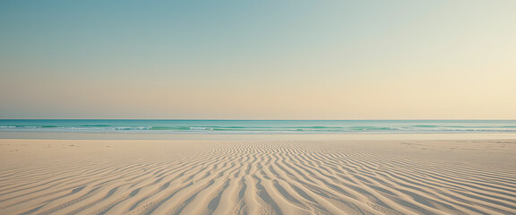 Naklejka premium Peaceful sandy beach with wave patterns at sunrise, calm ocean horizon and pastel sky creating tranquil summer vacation background, serene seascape for travel and relaxation 
