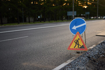 A Construction Zone Sign is prominently displayed on a road during the twilight hours at dusk