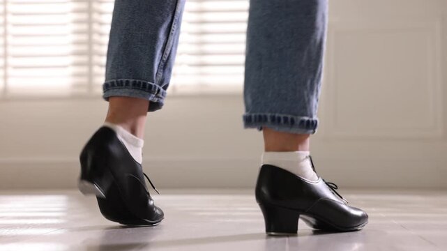 Teenage girl in tap shoes dancing indoors, closeup