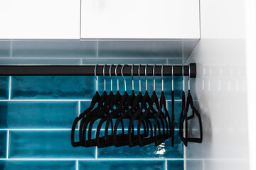 tidy laundry room with matching hangers white cabinets and teal tiled backsplash