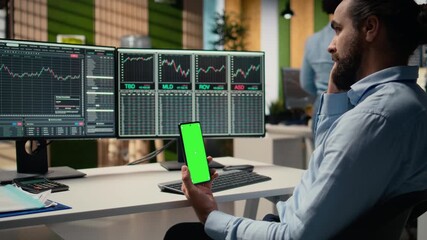 Equity analyst using green screen smartphone to reviews quarterly earnings, assessing stock market value. Trader conducts financial analysis using mockup mobile phone to improve investments, camera A - Powered by Adobe