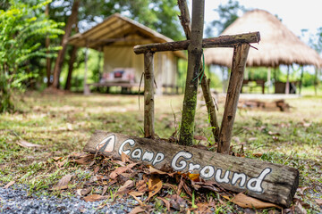 Night and warm light exposure of an illuminated bell tent surrounded by trees and a small camp fire, outdoor camping lifestyle