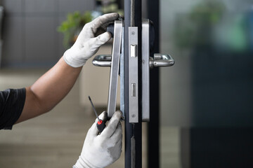 handymen using screwdriver to fix the door lock in the room