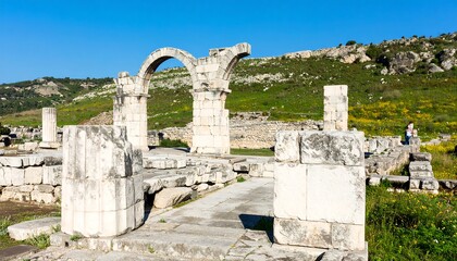 Ancient stone ruins of a building with arches and pillars.